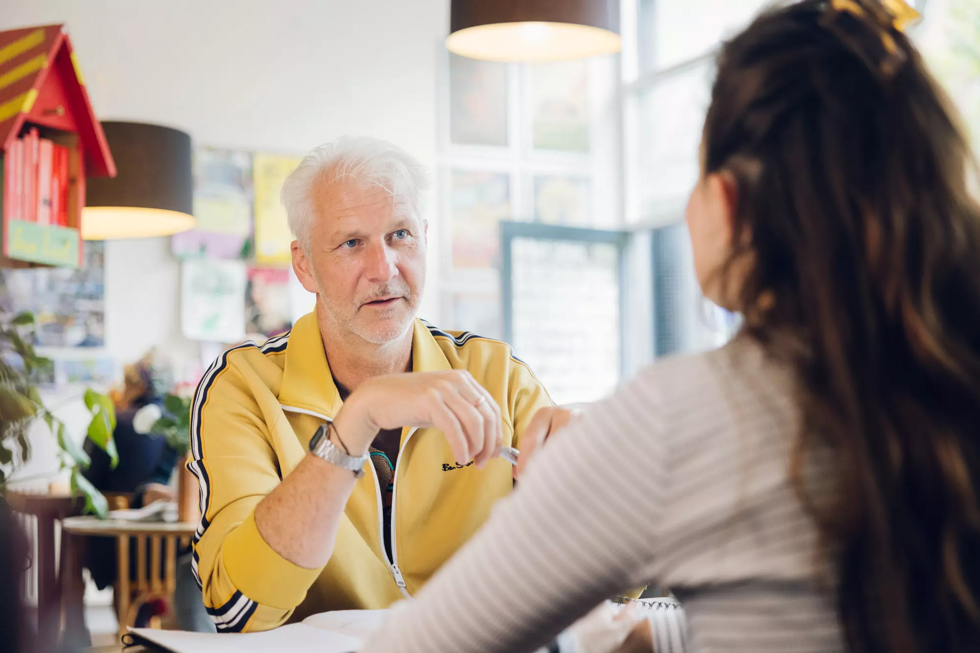 Lachende medewerker van Woonstad Rotterdam in gesprek met collega's. 