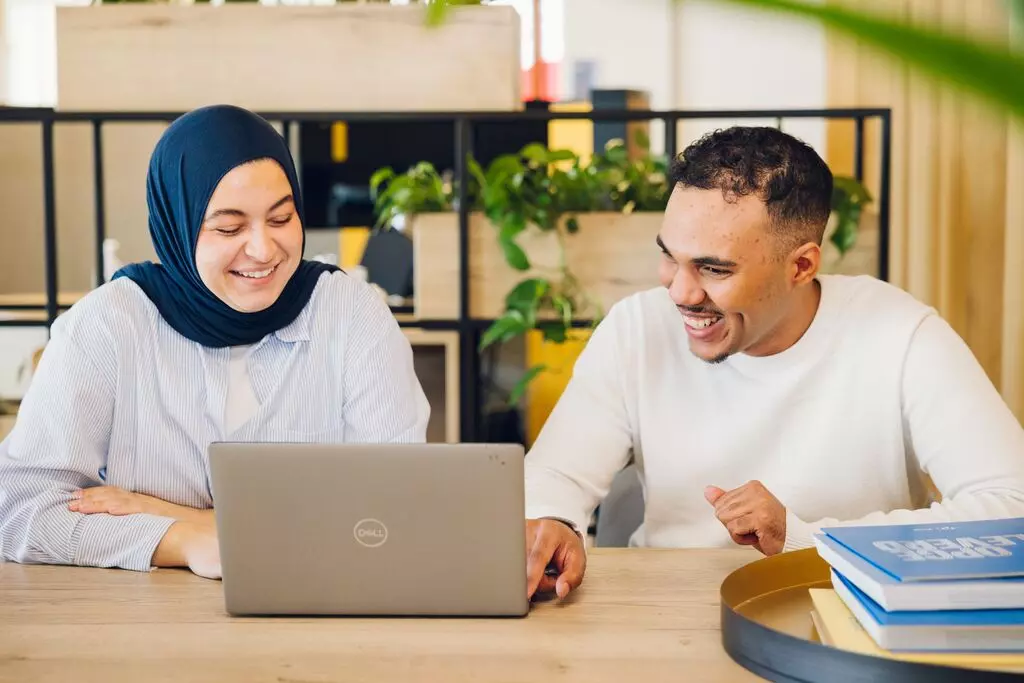 Medewerker Dagelijks Onderhoud in gesprek met bewoner voor reparatiebezoek.