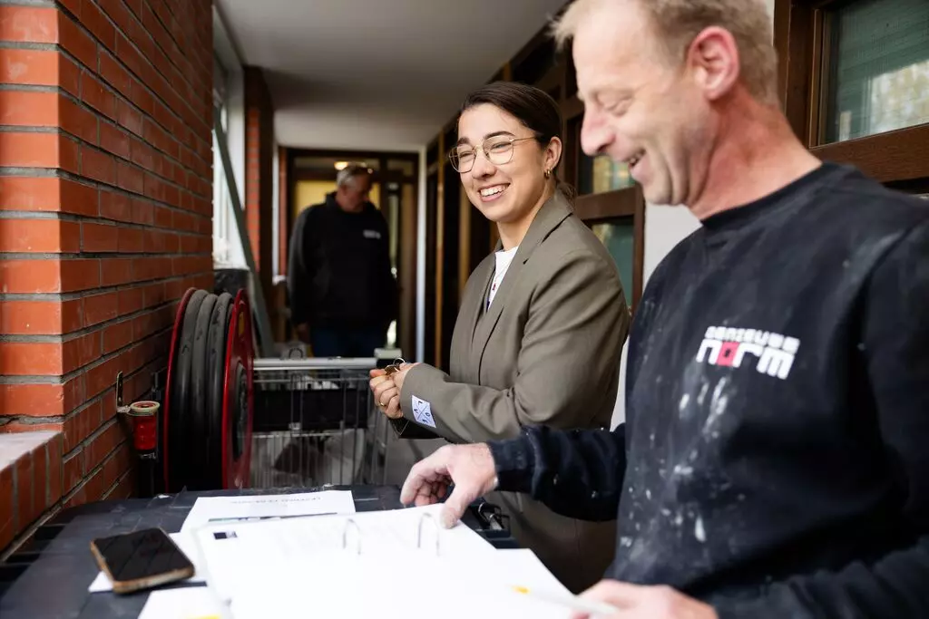 Projectleider Planmatig Onderhoud in gesprek met aannemer bij renovatie woningen.